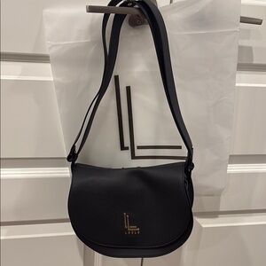 Brand new in bag. Stylish Black bag with gold emblem
